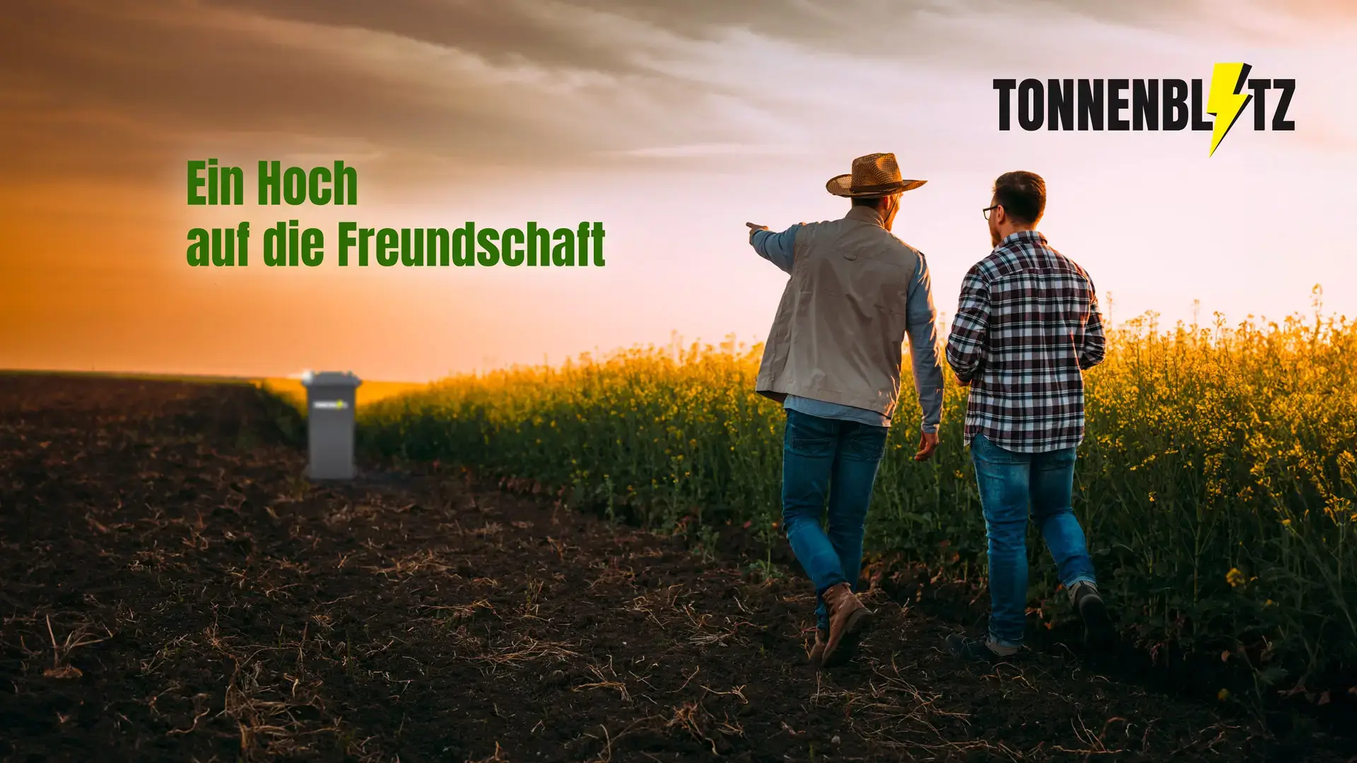wei Männer gehen bei Sonnenuntergang durch ein Feld und unterhalten sich, im Hintergrund steht eine Tonnenblitz-Mülltonne am Feldrand.