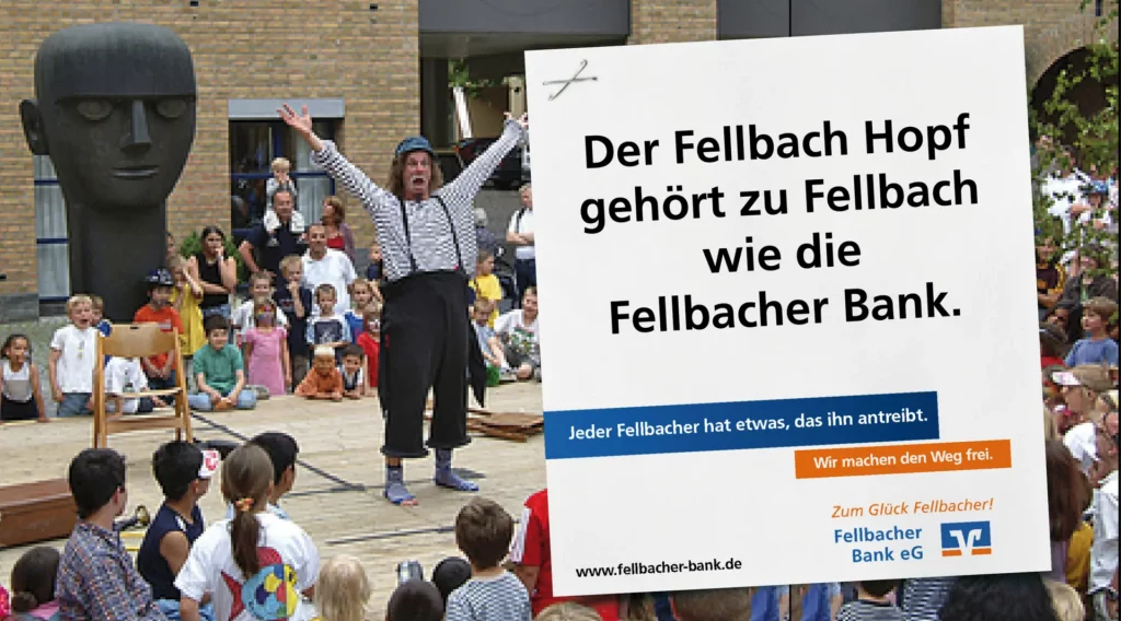 Großflächenmotiv der Fellbacher Bank mit dem Claim ‚Der Fellbach Hopf gehört zu Fellbach wie die Fellbacher Bank‘, aufgenommen während eines Kinder- und Straßenfests vor der Hopf-Skulptur.