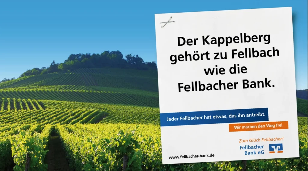 Großflächenmotiv der Fellbacher Bank mit dem Claim ‚Der Kappelberg gehört zu Fellbach wie die Fellbacher Bank‘ vor sonnigen Weinbergen am Kappelberg.
