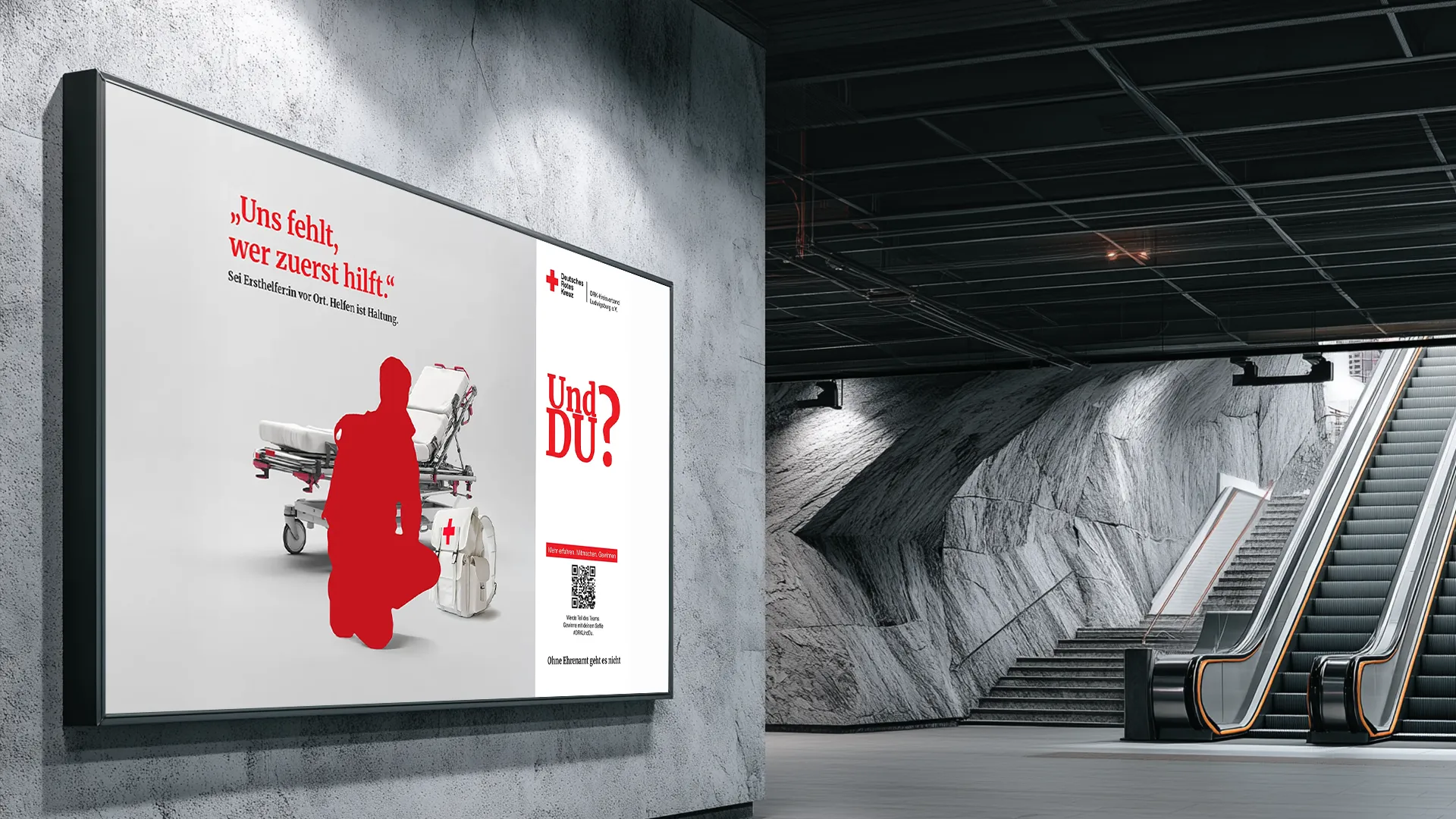 Rote Silhouette einer knienden Person neben einer Trage und einem Erste-Hilfe-Rucksack als symbolisches Kampagnenmotiv zur Suche nach Ersthelferinnen und Ersthelfern beim DRK.